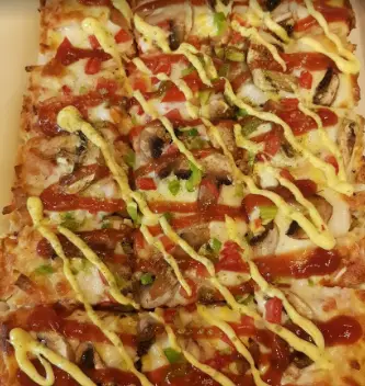 پیتزا مستطیلی صدف با پنیر، قارچ، فلفل دلمه‌ای، سس کچاپ و خردل، برش خورده و آماده سرو. پیتزا صدف.