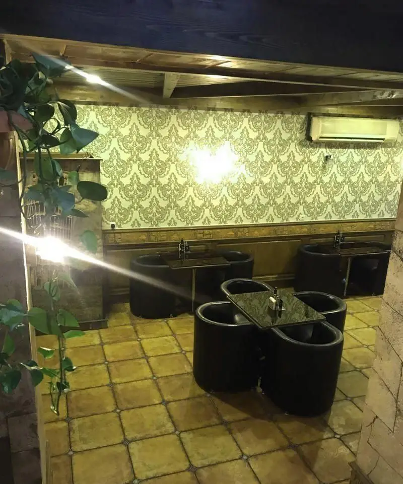 فضای داخلی کافی شاپ باربتا با دکوراسیون مدرن، دیوارپوش طرح‌دار زیبا، سقف چوبی، میز و صندلی‌های شیک و محیطی دنج و آرام برای مشتریان.