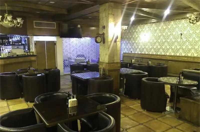 نمای داخلی کافی شاپ باربتا با دکوراسیون خاص و گرم، شامل میز و صندلی‌های راحت، سقف چوبی، بار نوشیدنی و نورپردازی محیطی دلنشین.