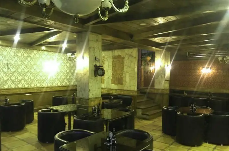 فضای داخلی دنج و شیک کافی شاپ باربتا با سقف چوبی، دیوارهای سنگی، میز و صندلی‌های مدرن و نورپردازی گرم و دلنشین.