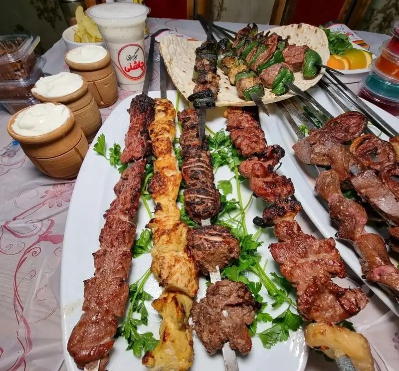 سفره رنگین و متنوع از انواع کباب‌های جگر، جوجه، کوبیده و چنجه در جگرکی چاشنی شعبه تهرانپارس همراه با دوغ و ماست محلی