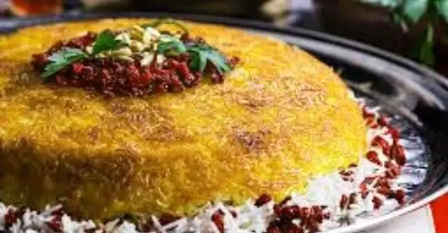 غذای اصیل ایرانی: ته چین زعفرانی کبابی پارس مغان با ته‌دیگ طلایی، تزیین شده با زرشک، پسته و سبزیجات تازه.