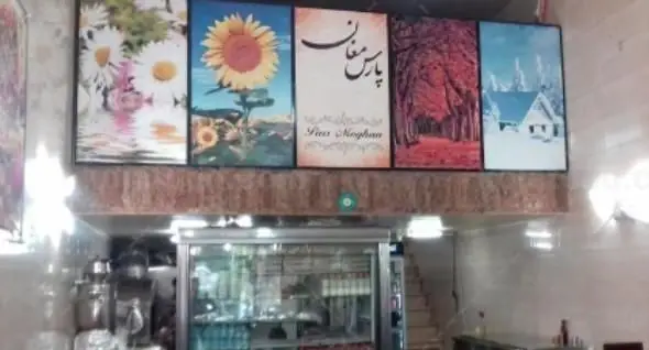 دکوراسیون داخلی کبابی پارس مغان، با تابلوهای فصول طبیعت و لوگوی رستوران، فضای گرم و جذاب برای تجربه غذای ایرانی.