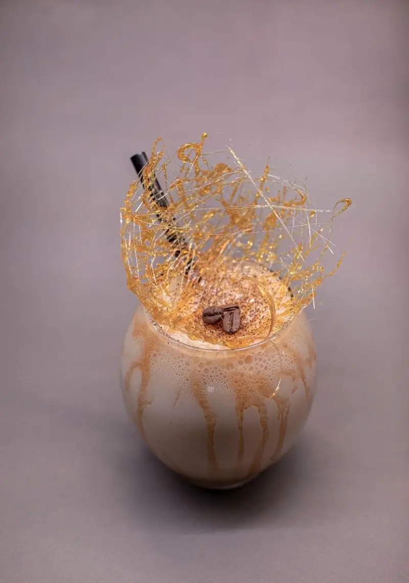 نوشیدنی سرد و دسر مخصوص کافه الوا: قهوه کارامل تزیین شده با شکر آب شده، پودر کاکائو و دانه قهوه. یک انتخاب خاص در Elva Cafe.