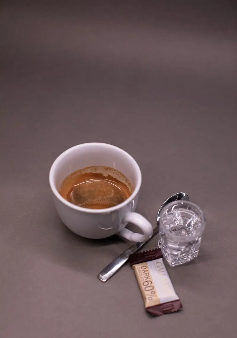 قهوه اسپرسو داغ با کرما، لیوان آب خنک و شکلات دارک 60 درصد گالاردو در کافه الوا. تجربه‌ای دلنشین و انرژی‌بخش.