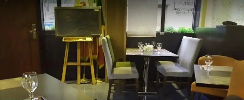 تصویری از دکوراسیون داخلی رستوران ایتالیایی کاپری، شامل چیدمان میز و صندلی‌های مدرن و شیک در فضایی گرم و دلپذیر برای تجربه غذایی لذت‌بخش.