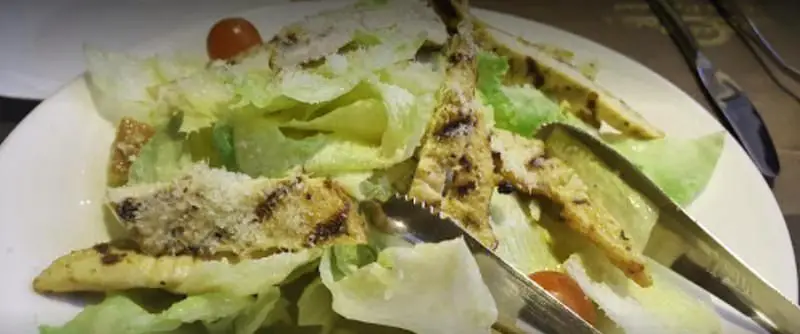 تصویری از سالاد سزار ویژه مرغ گریل شده با کاهو، گوجه گیلاسی و پنیر پارمزان، غذایی محبوب در رستوران ایتالیایی کاپری.