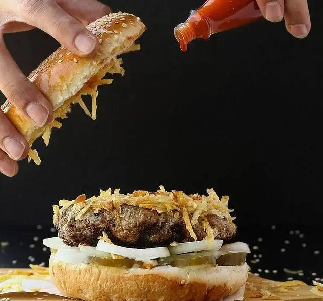 یک همبرگر بی‌نظیر از کافه رستوران رولینجا، با پیاز سوخاری ترد، سس تند، پیاز و خیارشور تازه. لذت یک طعم استثنایی.