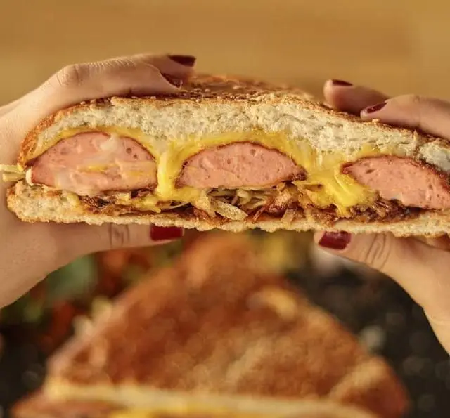 ساندویچ سوسیس و پنیر آب‌شده مخصوص کافه رستوران رولینجا؛ طعمی بی‌نظیر از نان برشته، سوسیس با کیفیت، پنیر ذوب‌شده طلایی و پیاز کاراملی خوش‌عطر.