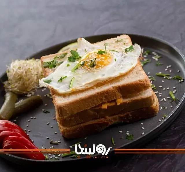 صبحانه خاص و خوشمزه کافه رستوران رولینجا: نان تست، تخم مرغ عسلی، پنیر، سبزیجات و دورچین تازه. انتخابی عالی برای شروع روز.