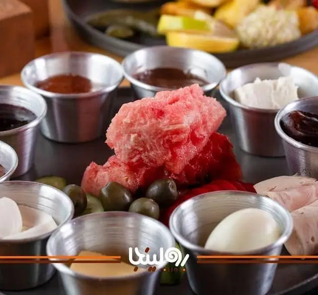 میز صبحانه لذیذ و متنوع کافه رستوران رولینجا شامل هندوانه، زیتون، تخم مرغ، پنیر و مربا برای یک شروع عالی روز.