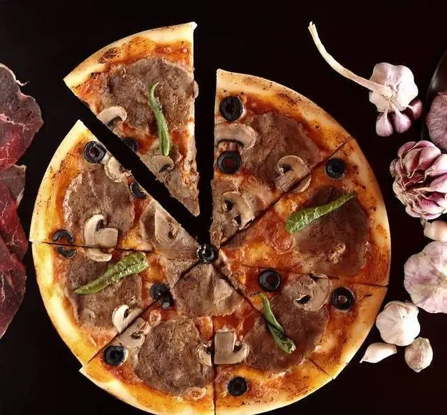 پیتزا گوشت و قارچ با زیتون و فلفل سبز از کافه رستوران رولینجا، نمایی جذاب از غذای لذیذ برای عاشقان پیتزا.