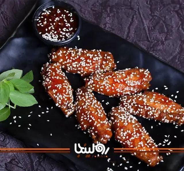 غذای خوشمزه و جذاب بال مرغ کنجدی سس‌دار مخصوص کافه رستوران رولینجا. بهترین وینگز آسیایی را در رولینجا تجربه کنید.