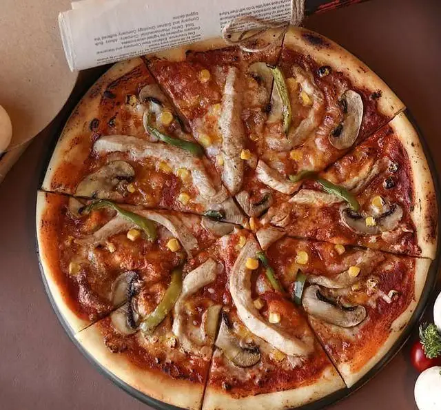 پیتزا مرغ و قارچ کافه رستوران رولینجا با ذرت و فلفل دلمه، تازه و خوشمزه. تجربه‌ای لذیذ از بهترین غذاهای ایتالیایی در رولینجا.