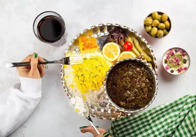 قورمه سبزی اصیل ایرانی و پلو زعفرانی، همراه با ته دیگ، ترشیجات، زیتون و ماست و خیار. تجربه طعم بی نظیر با غذای انصار.