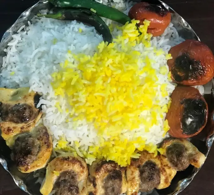 چلوکباب مخلوط لذیذ (جوجه و کوبیده) از رستوران حبیب تهرونی، با برنج زعفرانی معطر، گوجه و فلفل کبابی تازه. بهترین غذای ایرانی.