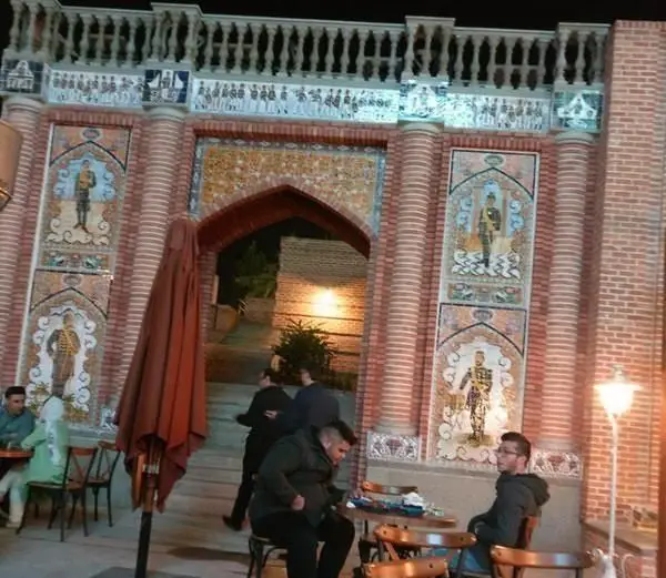 تصویری از ورودی چشم‌نواز رستوران ایرانی دروازه طهرون با معماری سنتی، ستون‌های آجری و کاشی‌کاری‌های قدیمی. فضای باز مناسب برای صرف غذا.