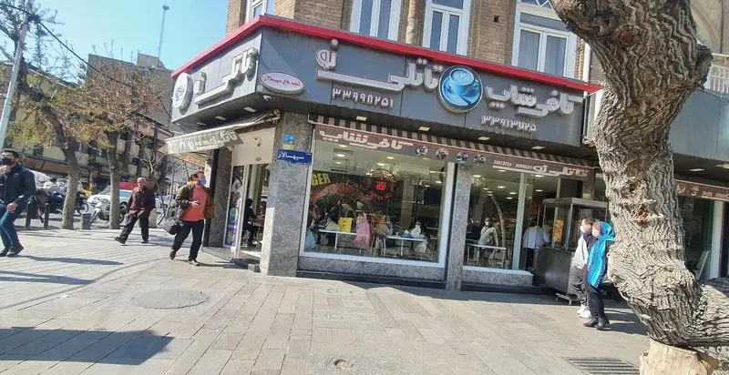 فست فود و کافی شاپ تاتلی نو، واقع در خیابان سهسالار با نمای بیرونی شلوغ و رهگذران در روز آفتابی.
