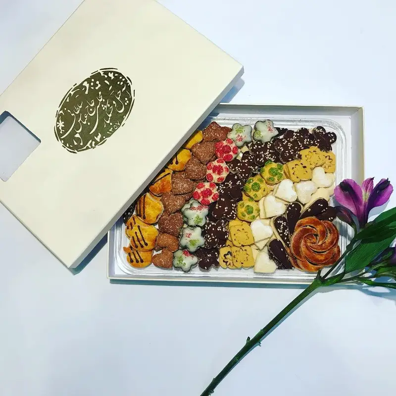 جعبه‌ای شکیل از شیرینی‌های مخلوط و سوهان لقمه‌ای حاج عباس سلطانی، شامل کوکی و شیرینیجات تازه و خوشمزه، هدیه‌ای ارزشمند.