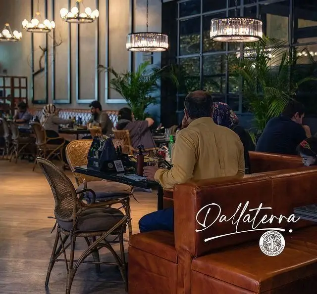 فضای داخلی دنج و شیک رستوران و کافه دالاترا با مشتریان در حال غذاخوری و نورپردازی مدرن و زیبا.