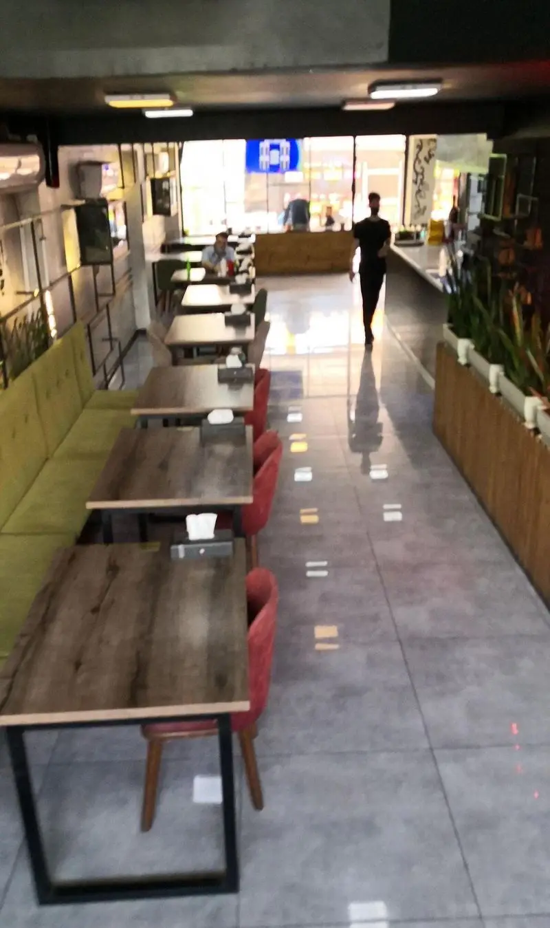 فضای داخلی فست فود لیرو با دکوراسیون شیک و مدرن، چیدمان منظم میز و صندلی‌ها و محیطی دلپذیر برای تجربه غذایی لذت‌بخش.