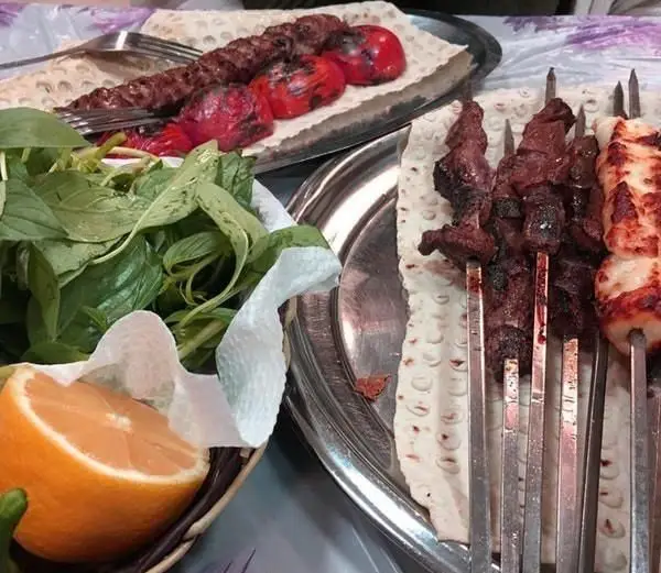 جگر سرای سالار: میز غذای لذیذ ایرانی شامل جگر، جوجه و کوبیده کباب با گوجه کبابی، نان لواش تازه، سبزی و مرکبات.