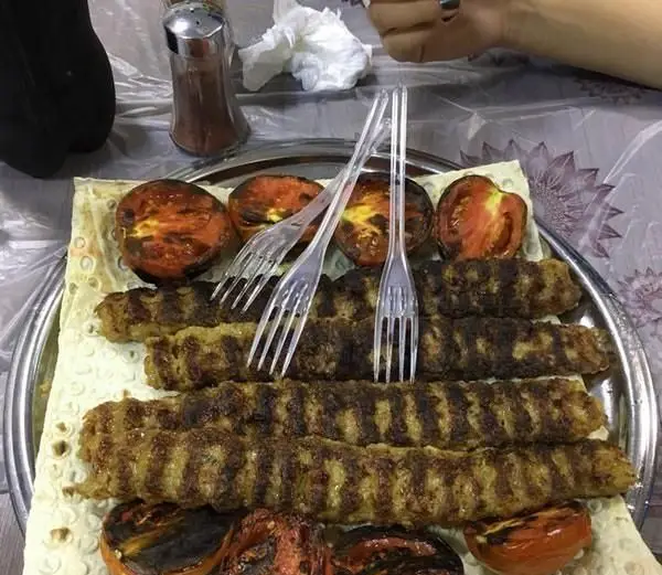 سینی وسوسه‌انگیز از کباب کوبیده تازه و گوجه کبابی در جگر سرای سالار، آماده سرو با نان داغ، تجربه‌ای لذیذ از غذای اصیل ایرانی.