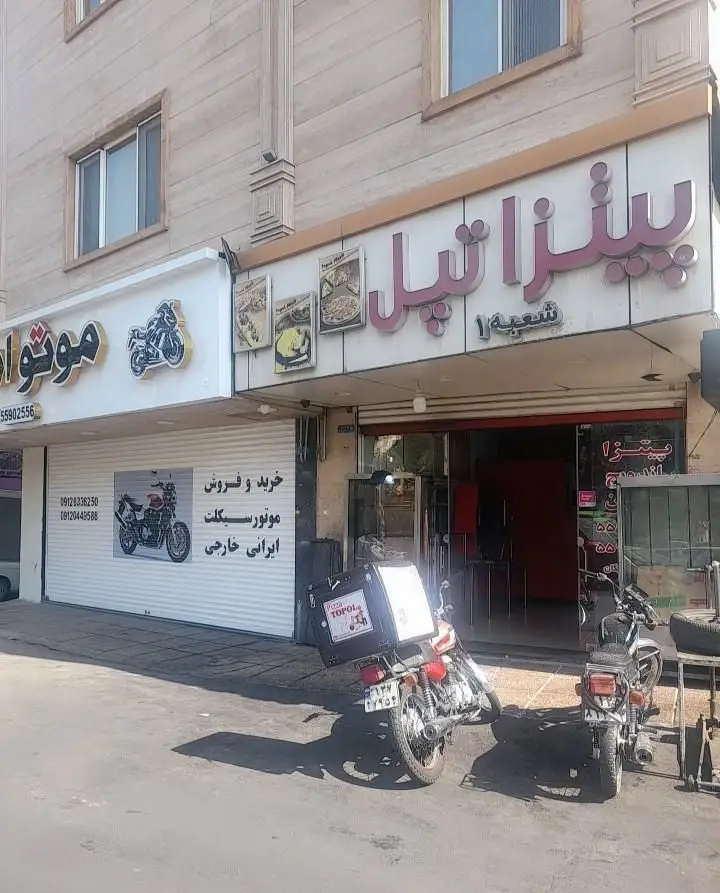 نمای بیرونی پیتزا تپل، یک رستوران فست فود با موتورسیکلت های دلیوری، در کنار فروشگاه موتورسیکلت. آماده سفارش پیتزا.