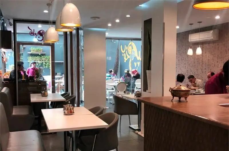 فضای داخلی رستوران و کافی‌شاپ سان لیو با میز و صندلی‌های مدرن و راحت، مشتریان در حال صرف غذا و نوشیدنی در محیطی دلنشین و آرام.