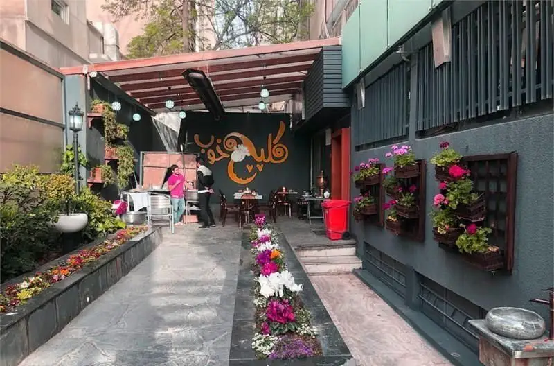 فضای سبز و زیبای ذستوران سان لیو با باغچه های گلرنگ، مسیر دلنشین و میزهای چوبی در محوطه باز، مکانی ایده آل برای لذت غذا.