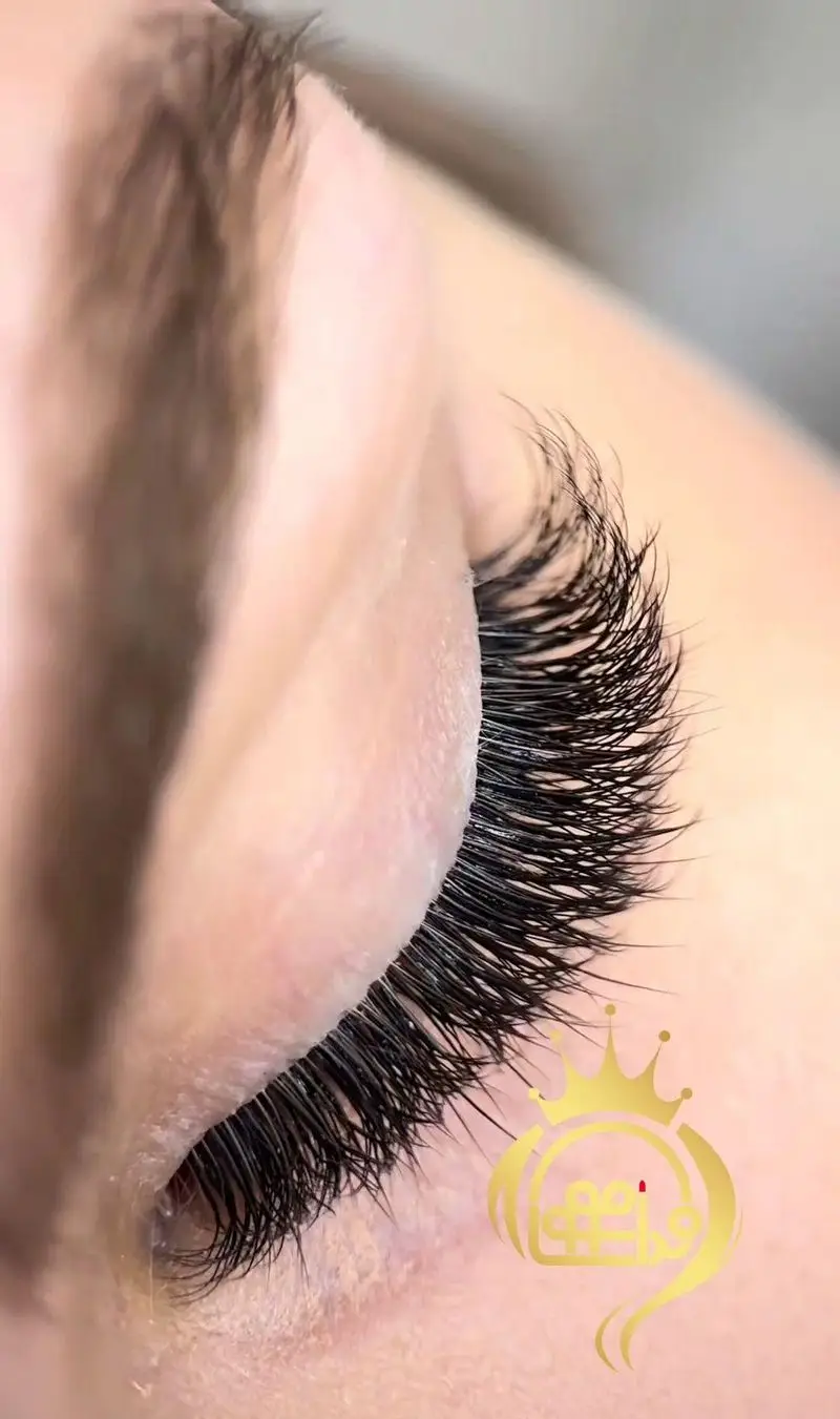 نمای نزدیک از اکستنشن مژه والیوم پرپشت و مشکی روی چشم بسته زنانه در آرایشگاه زنانه ندا موسوی جهت نمایش ظرافت کاشت مژه