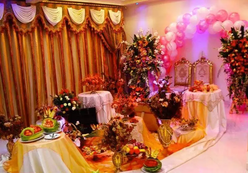 تالار قصر گوهر: دکوراسیون مجلل و گل‌آرایی زیبا برای سفره عقد و مراسم عروسی، با میزهای آراسته و بادکنک‌آرایی چشم‌نواز.
