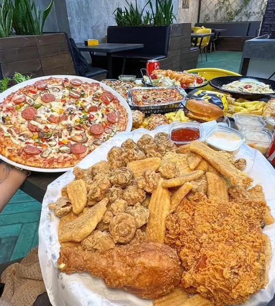 میزی شاهانه از غذاهای لذیذ پیتزا کندیک: پیتزای ویژه، مرغ کنتاکی ترد و سیب زمینی، پاستا، برگر، سالاد و سس. انتخابی عالی برای دورهمی و مهمانی.