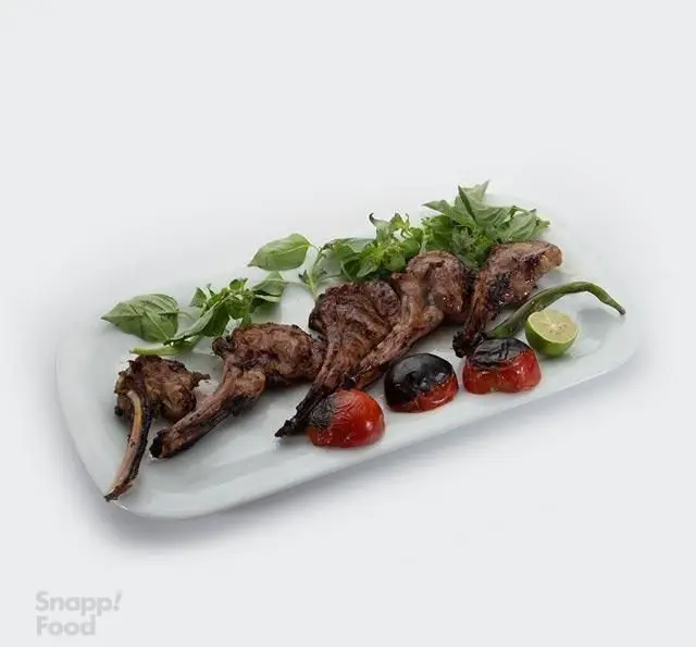 شیشلیک لذیذ و مخصوص کبابی نون و ریحون، سرو شده با گوجه کبابی، فلفل سبز، لیموترش و ریحون تازه. بهترین غذای ایرانی.