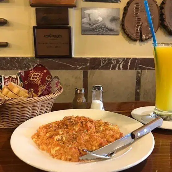 صبحانه جذاب و لذیذ کافه لینت: املت گوجه و تخم مرغ، نان برشته، آب پرتقال تازه در فضایی آرام و دلنشین.