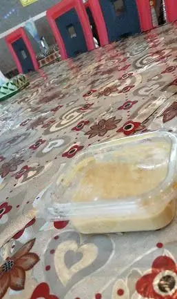 تصویری از میز رستوران موسوی با رومیزی زیبا و طرح‌دار، حاوی یک ظرف دسر یا دیپ خوش‌طعم. لذت طعم و کیفیت در فضایی دلنشین.