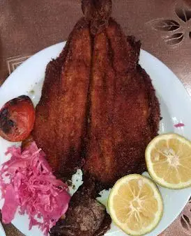 ماهی سرخ شده مجلسی با لیمو، گوجه کبابی و ترشی، غذای دریایی خاص و لذیذ رستوران موسوی، انتخابی عالی برای ناهار و شام.