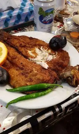یک بشقاب ماهی سرخ شده لذیذ و طلایی در رستوران موسوی، همراه با فلفل سبز تند و لیمو. بهترین انتخاب برای یک وعده غذایی دلپذیر.