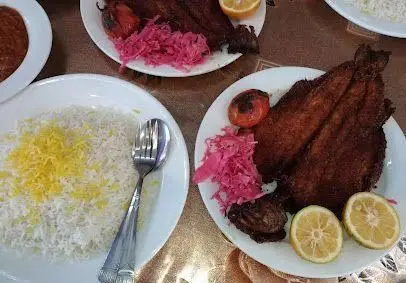 عکس غذای لذیذ رستوران موسوی شامل ماهی سرخ شده، پلو با زعفران و ترشی کلم. بهترین غذای ایرانی را اینجا بیابید.