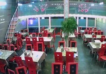 نمای داخلی رستوران موسوی با میز و صندلی‌های چیده شده، فضای بزرگ سالن غذاخوری دو طبقه و دکوراسیون دلنشین.