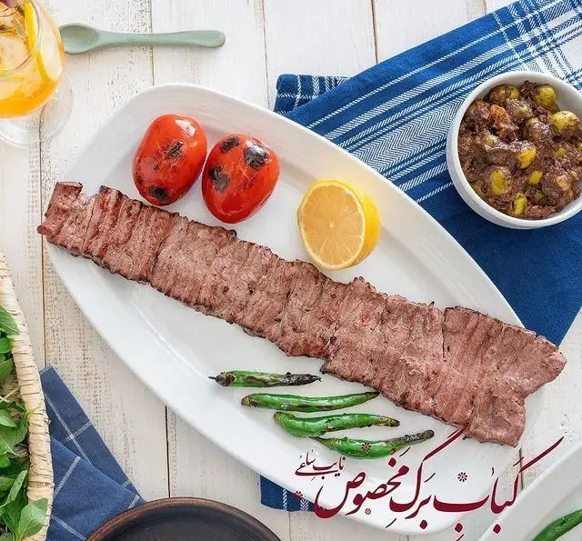 کباب برگ مخصوص بوفه نایب ساعی، یک غذای اصیل و لذیذ ایرانی همراه با گوجه کبابی، لیمو و فلفل سبز. تجربه طعم بی‌نظیر در رستوران.