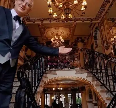 ورودی باشکوه بوفه نایب ساعی با میزبانی گرم، دکوراسیون داخلی مجلل، راه پله‌ کلاسیک و لوسترهای درخشان.