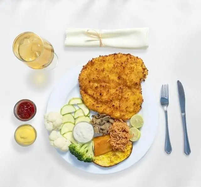 خوراک کامل و متنوع بوفه نایب ساعی: شنیتسل طلایی با سس‌های گوناگون، سبزیجات تازه و نوشیدنی. ایده‌آل برای یک وعده عالی در رستوران نایب ساعی.