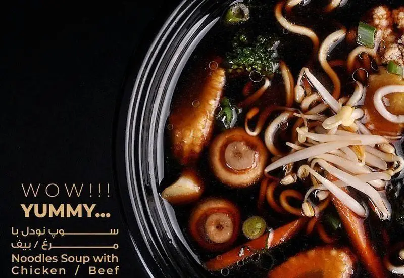 کاسه سوپ نودل گرم و خوشمزه رستوران بامبو اکسپرس با تکه‌های مرغ یا گوشت، قارچ، جوانه و سبزیجات تازه. انتخابی عالی برای دوستداران غذای آسیایی.