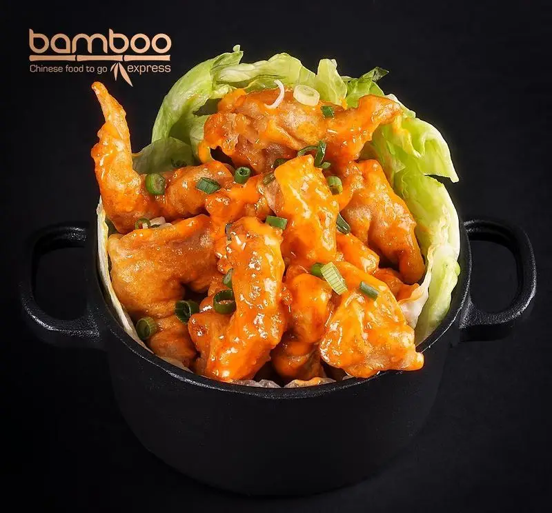 میگو دینامیت یا مرغ سوخاری با سس پرتقالی مخصوص رستوران بامبو اکسپرس. غذای چینی آماده خوشمزه تو گو با کاهو و پیازچه تازه.