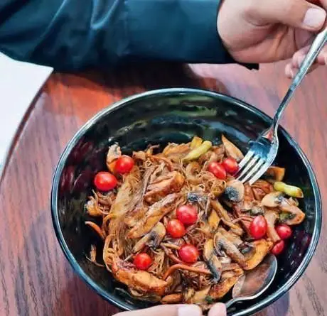 لذت تجربه یک وعده غذایی لذیذ و سالم در کافی شاپ سیمو؛ کاسه ای پر از نودل با گوشت ریش ریش، قارچ و گوجه گیلاسی تازه.