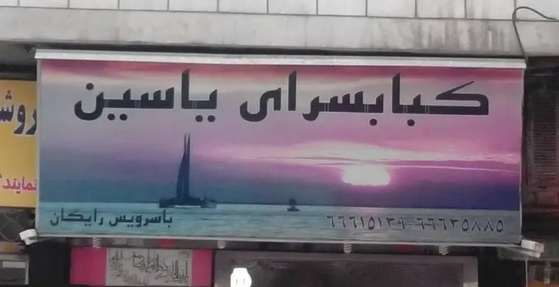 تابلوی کباب سرای یاسین با منظره غروب دریا، ارائه دهنده غذای ایرانی و انواع کباب با سرویس رایگان. شماره تلفن 7771569 و 77725885.