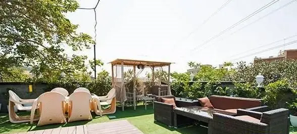 فضای باز دلنشین روف گاردن کافی شاپ شاندیز اعیانی با مبلمان راحتی، آلاچیق و فضای سبز برای آرامش و دورهمی.