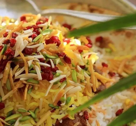 مرصع پلو زعفرانی کافه روحی در باغ نگارستان؛ برنج معطر با خلال بادام، پسته، زرشک، خلال پرتقال و گوشت، غذای اصیل ایرانی.