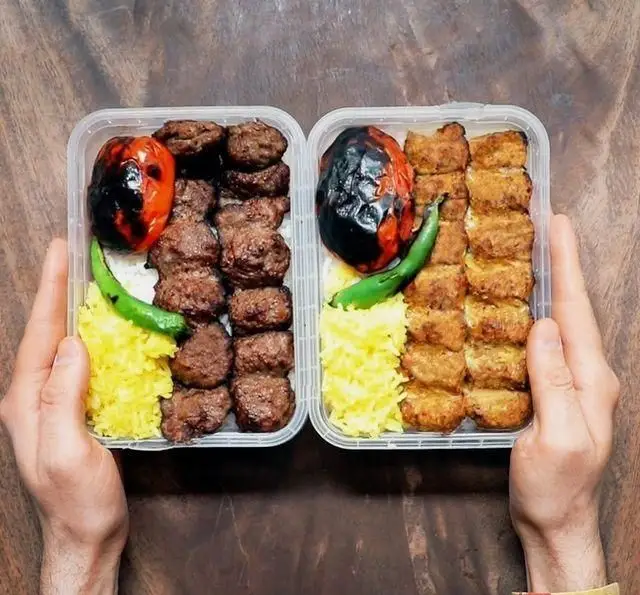 دو پرس غذای بیرون‌بر شامل انواع کباب، برنج زعفرانی، گوجه و فلفل کبابی. غذای خوشمزه از کافه روحی باغ نگارستان.